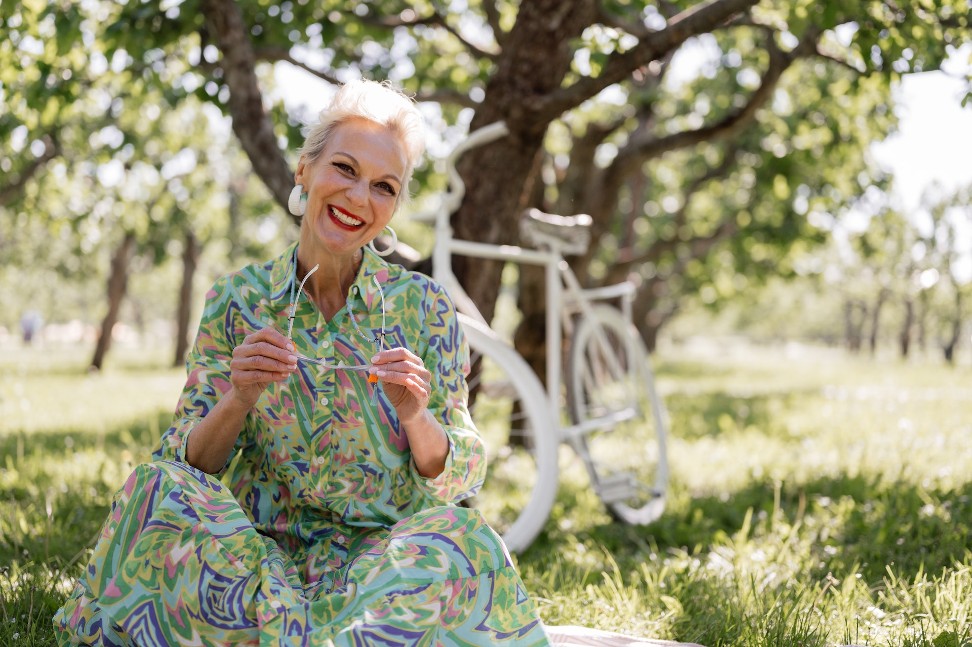 older lady sitting outside under a tree 